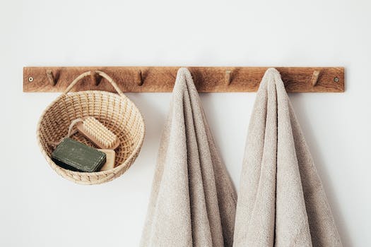 A towel hanging on the wall next to a basket of soap.